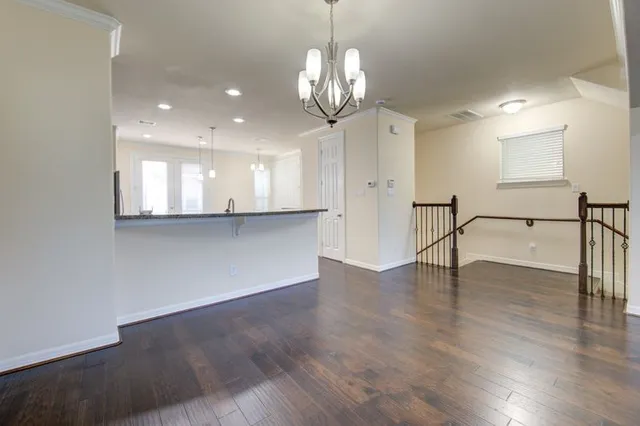 a view of a big room with wooden floor and a chandelier