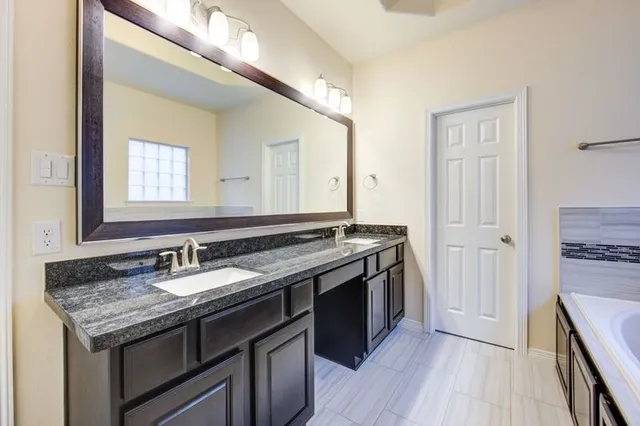 a bathroom with a granite countertop sink and a mirror