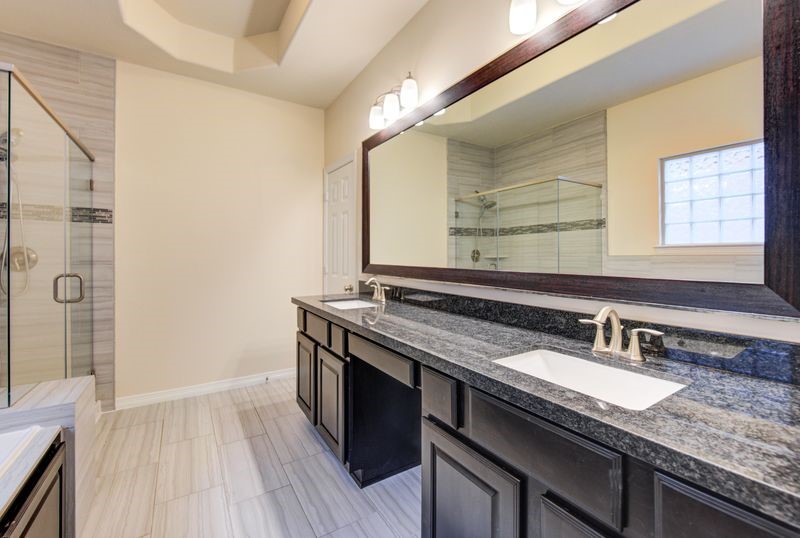10014 Spring Shadows Park Circle Houston, TX 77080 - Photo 21 of 39 a bathroom with a granite countertop sink a mirror and a shower