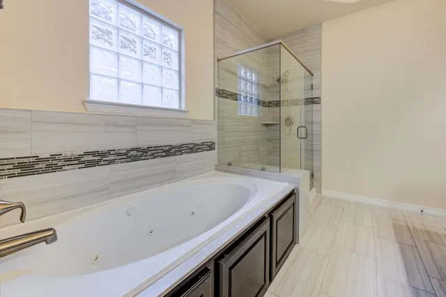 a bathroom with a granite countertop sink and a bathtub