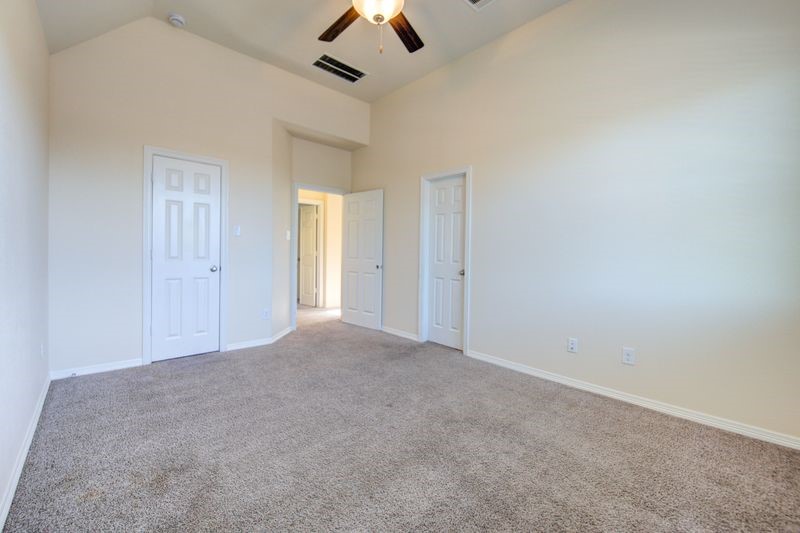 10014 Spring Shadows Park Circle Houston, TX 77080 - Photo 26 of 39 an empty room with chandelier fan and windows