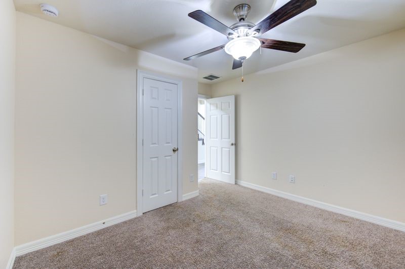 10014 Spring Shadows Park Circle Houston, TX 77080 - Photo 34 of 39 an empty room with a chandelier fan and a ceiling fan