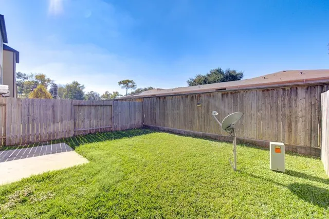 a view of a backyard with a fence and plants