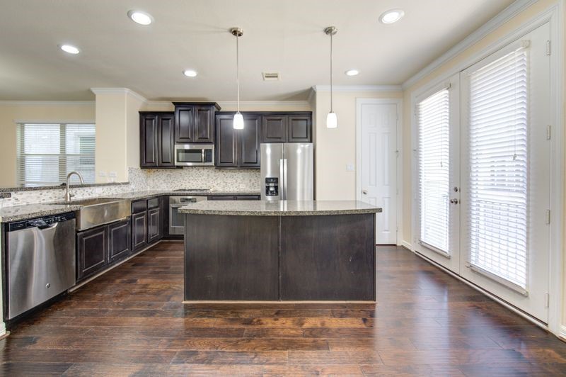 10014 Spring Shadows Park Circle Houston, TX 77080 - Photo 5 of 39 a kitchen with stainless steel appliances granite countertop a sink a stove a refrigerator and a oven with wooden floor