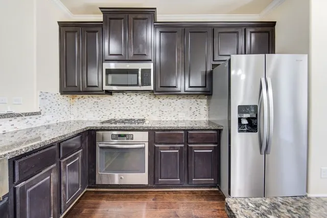 a kitchen with granite countertop stainless steel appliances and wooden cabinets