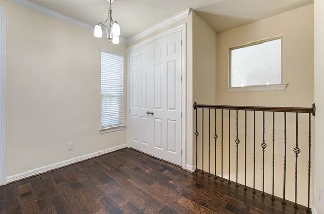 an empty room that has a window and wooden floor