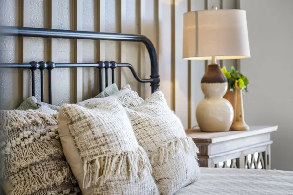 a bedroom with a bed a painting on the wall and a window