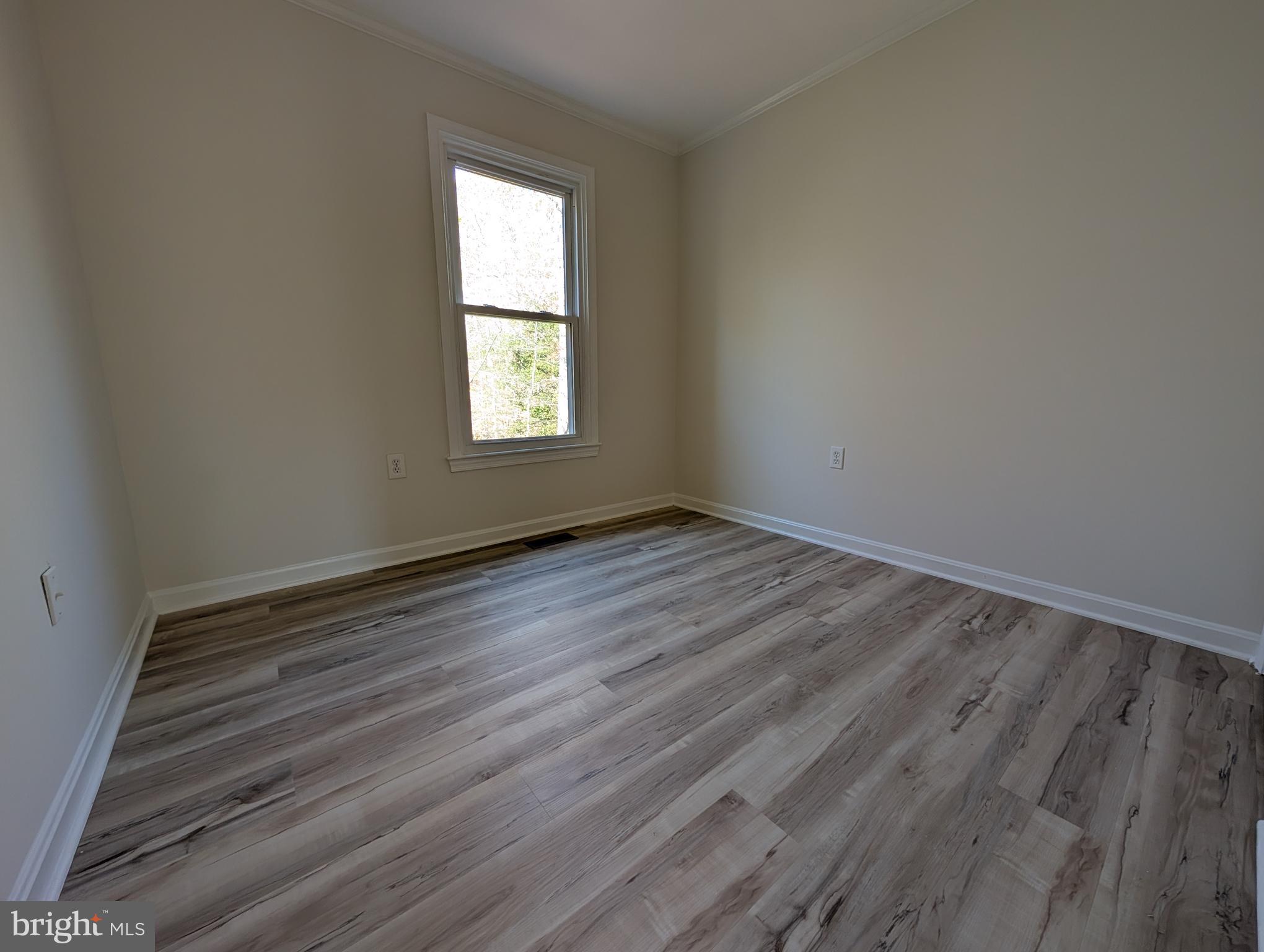 8108 Squirrel Run Road Springfield, VA 22152 - Photo 12 of 16 an empty room with wooden floor and windows