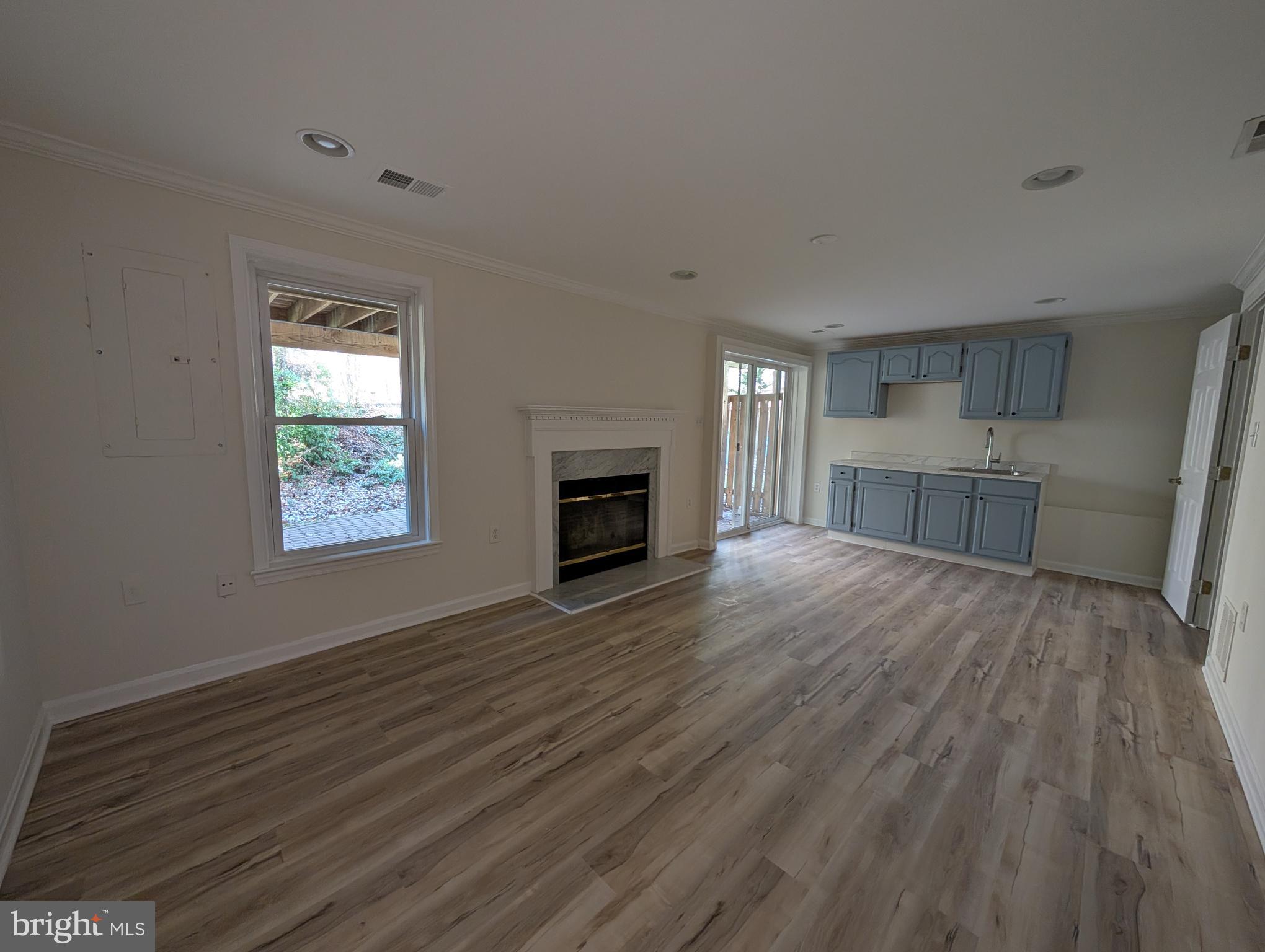 8108 Squirrel Run Road Springfield, VA 22152 - Photo 15 of 16 an empty room with wooden floor a fireplace and windows