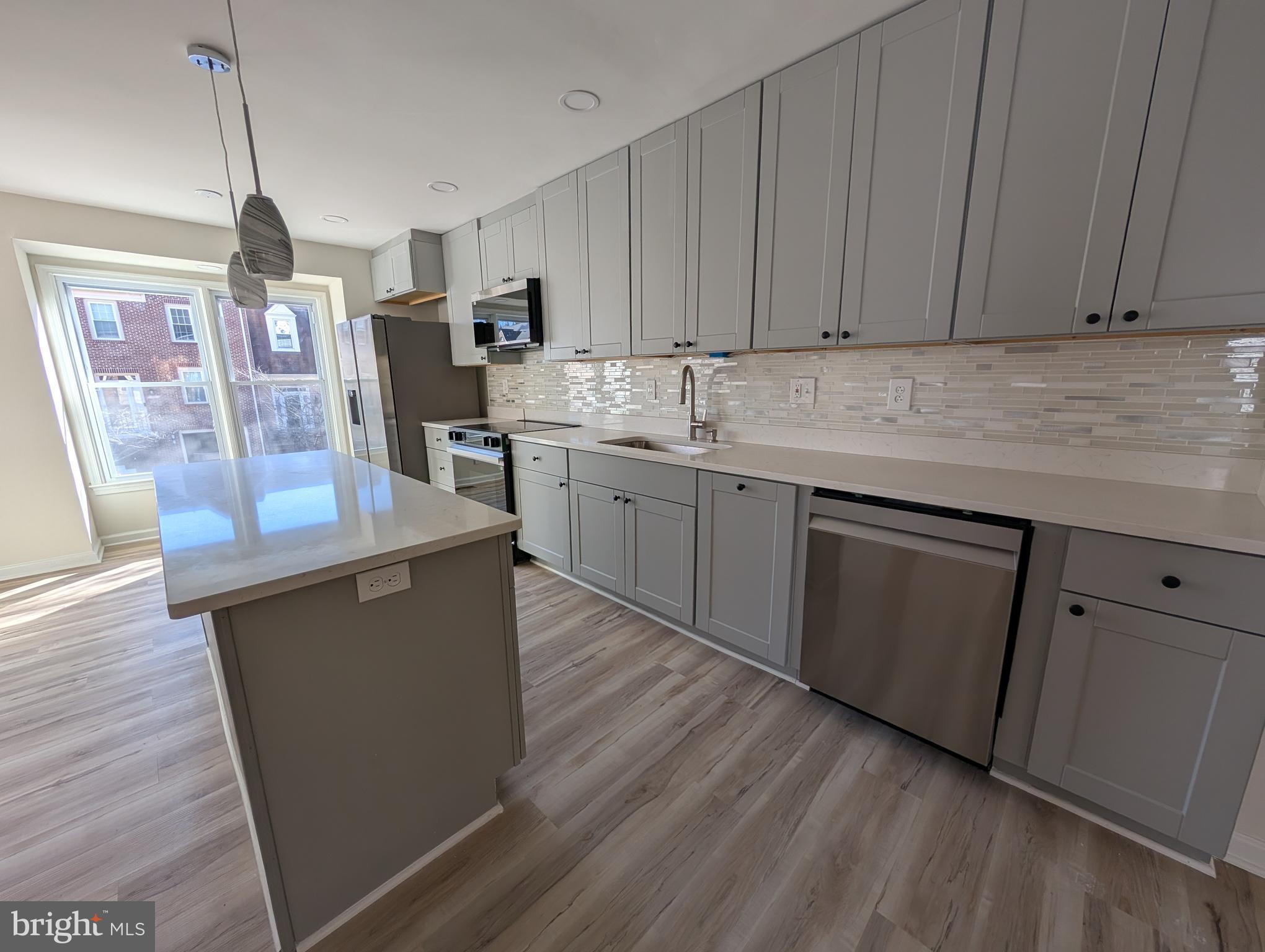 8108 Squirrel Run Road Springfield, VA 22152 - Photo 3 of 16 a kitchen with stainless steel appliances granite countertop a refrigerator a sink dishwasher a stove top oven a dining table and chairs with wooden floor