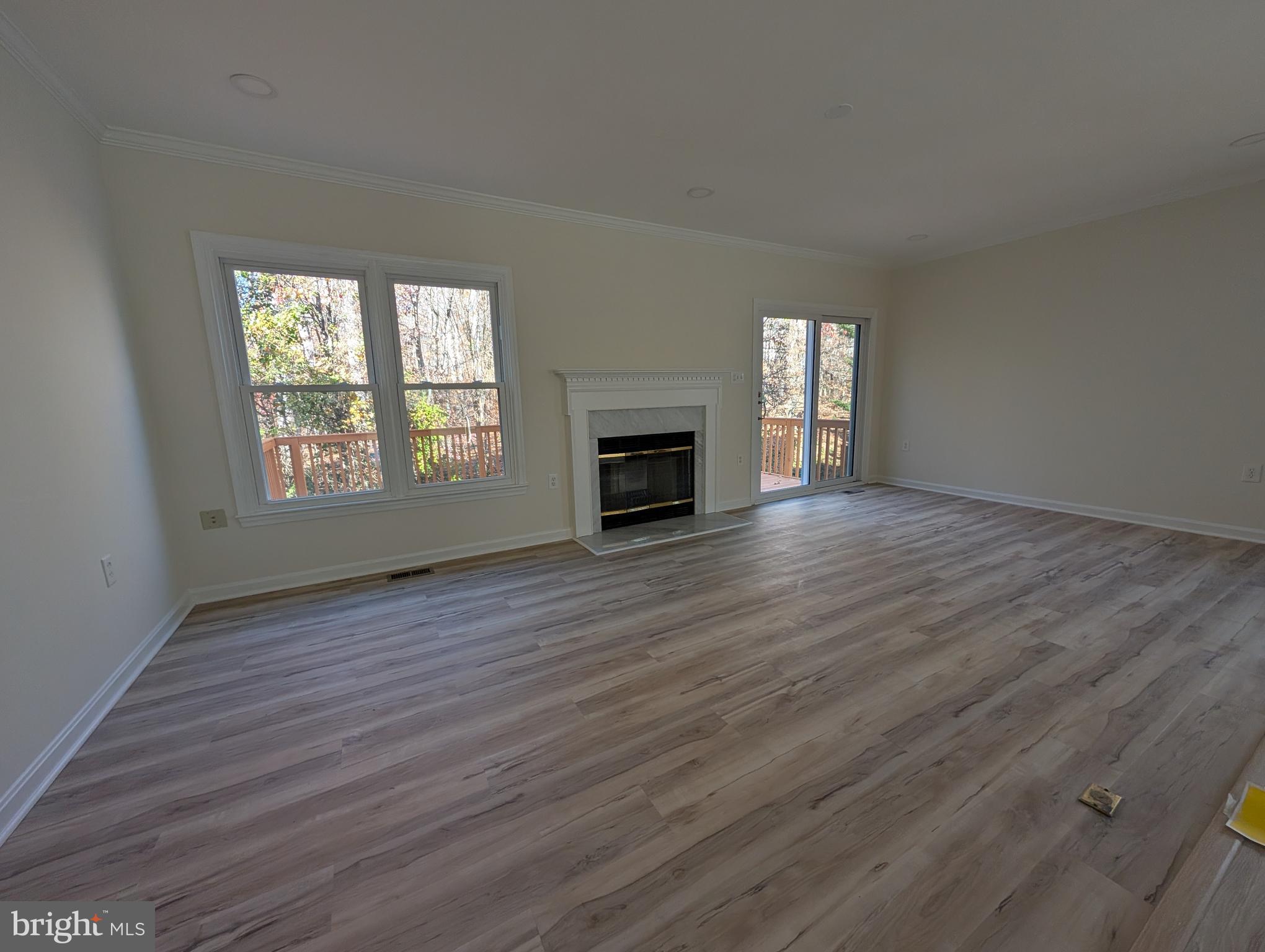 8108 Squirrel Run Road Springfield, VA 22152 - Photo 4 of 16 an empty room with wooden floor fireplace and windows