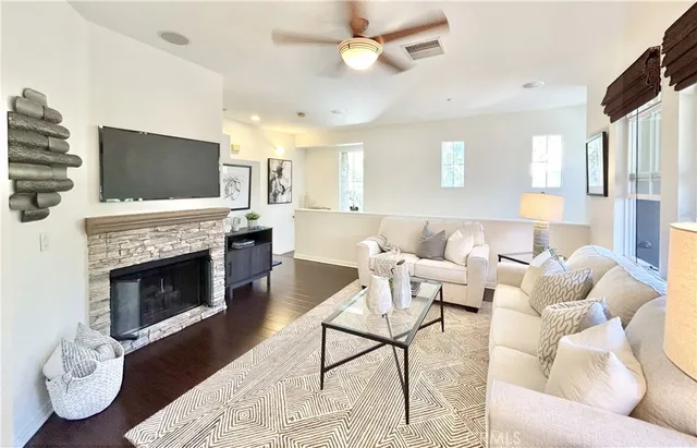 a living room with furniture a fireplace and a flat screen tv