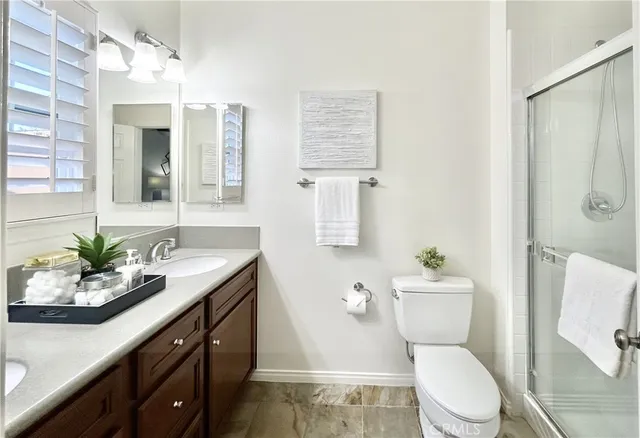a bathroom with a granite countertop sink toilet and shower
