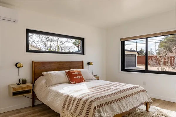 a bedroom with a bed and a painting on the wall