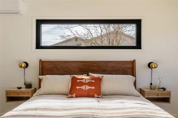 a bedroom with a bed and a painting on the wall