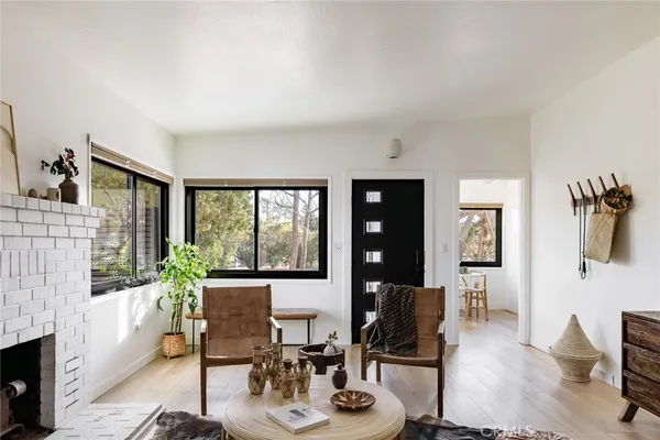 a living room with furniture a large window and wooden floor