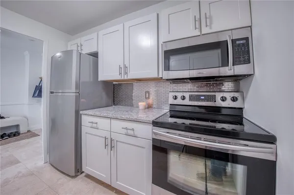 a kitchen with cabinets stainless steel appliances and a counter space