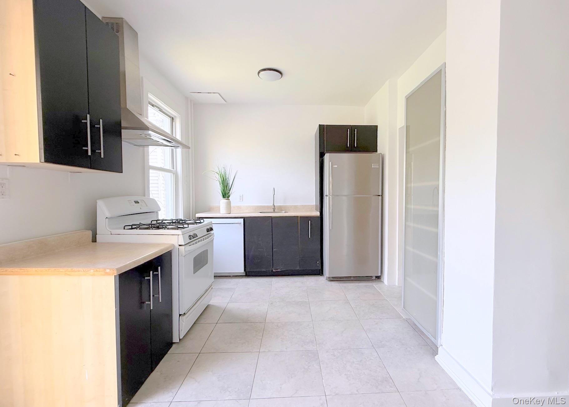 35 7th Street New Rochelle, NY 10801 - Photo 9 of 18 a large kitchen with a stove and a refrigerator
