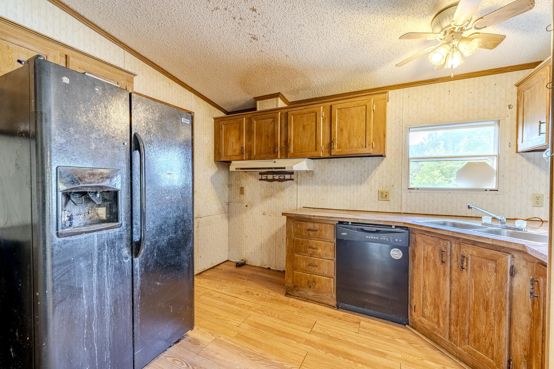 859 Old Morris Chapel Road Adamsville, TN 38310 - Photo 22 of 39 Kitchen area featuring wood-finish flooring, wood cabinetry, and a ceiling fan with integrated lighting