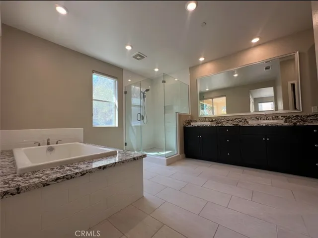 a spacious bathroom with a granite countertop sink and a mirror