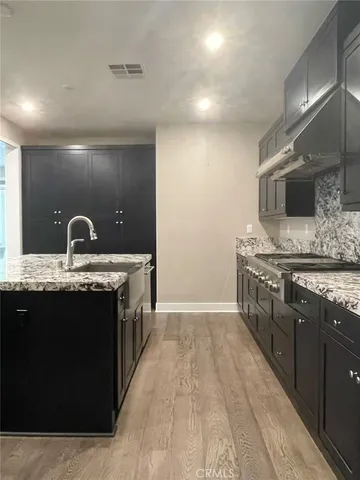 a kitchen with stainless steel appliances granite countertop a sink and a stove