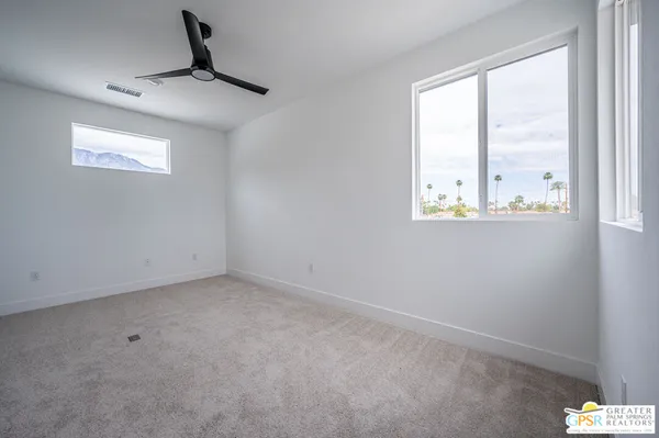 an empty room with windows and cabinet