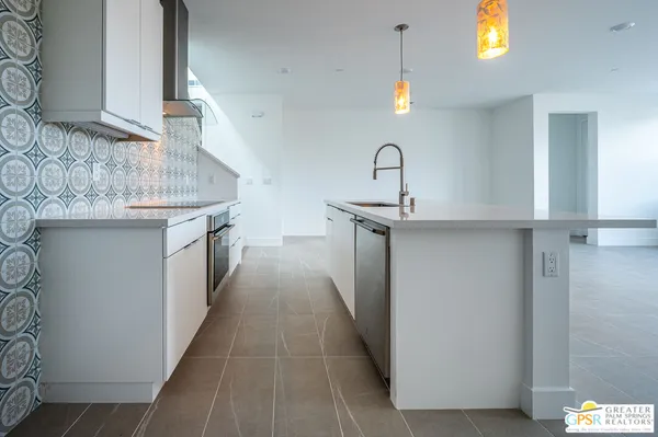 a kitchen with granite countertop white cabinets stainless steel appliances and a counter space