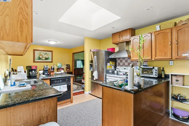 a kitchen with stainless steel appliances granite countertop a sink stove and refrigerator