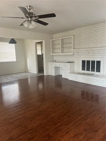 a view of a livingroom with wooden floor and a ceiling fan