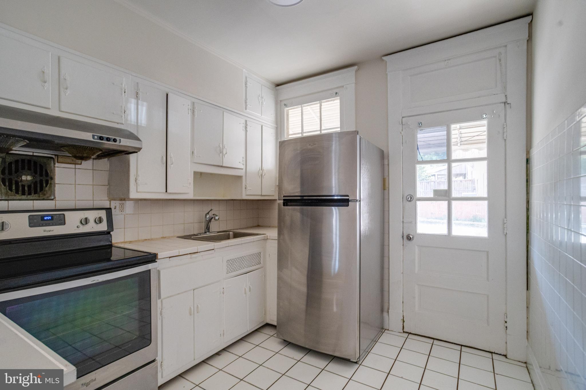 5878 Belair Road Baltimore, MD 21206 - Photo 16 of 41 a kitchen with a refrigerator sink and cabinets