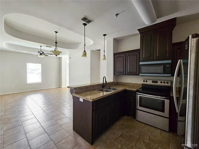 a kitchen with kitchen island granite countertop a stove cabinets and refrigerator