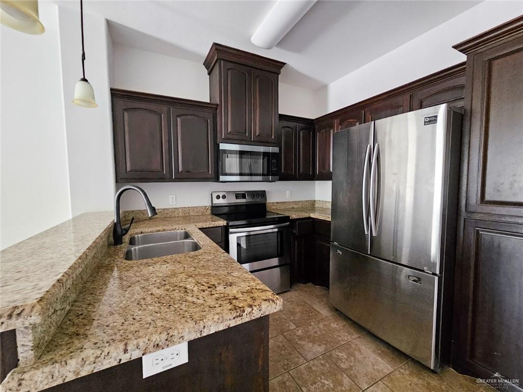 1819 South Texas Boulevard Weslaco, TX 78596 - Photo 4 of 8 a kitchen with granite countertop a refrigerator and a sink