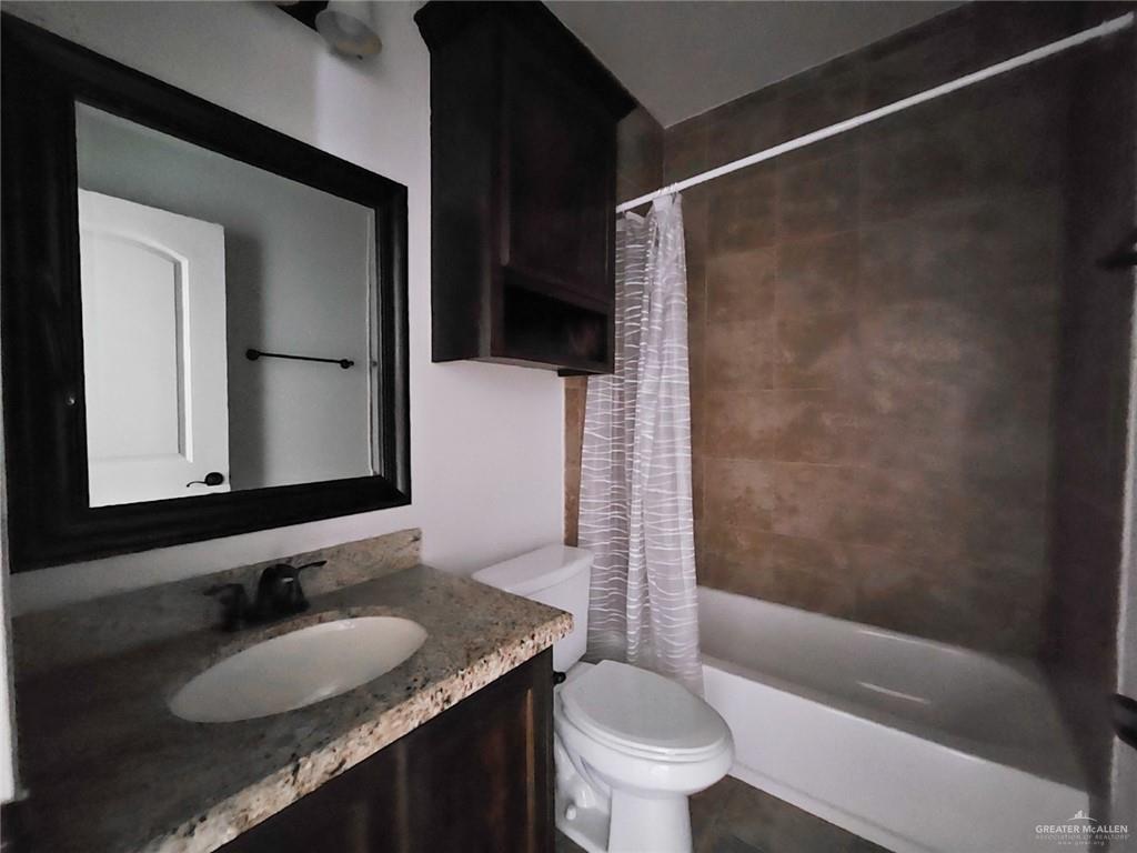 1819 South Texas Boulevard Weslaco, TX 78596 - Photo 8 of 8 a bathroom with a granite countertop sink toilet and shower