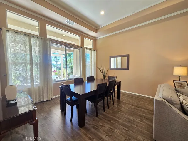 a view of a a dining room with furniture window and wooden floor