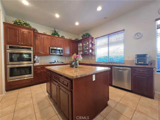 a large kitchen with kitchen island a large counter top space appliances and a counter space
