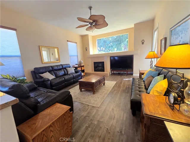 a living room with furniture kitchen view and a chandelier