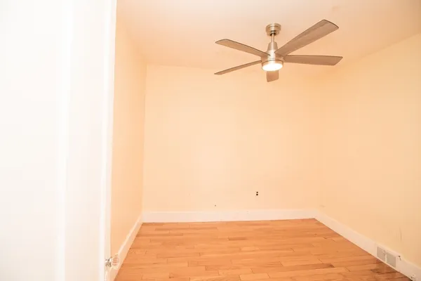 a view of a room with a ceiling fan and a window