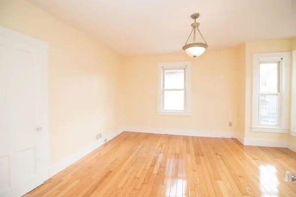 a view of a room with wooden floor and windows