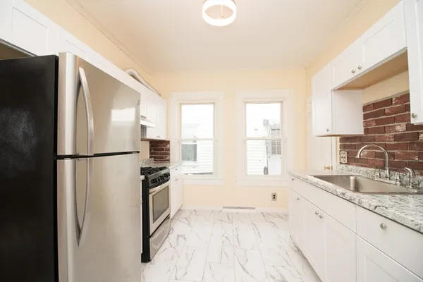 a kitchen with granite countertop a refrigerator and a sink