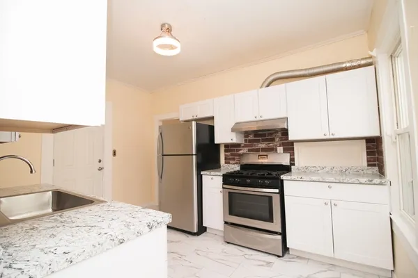 a kitchen with a sink stove and refrigerator