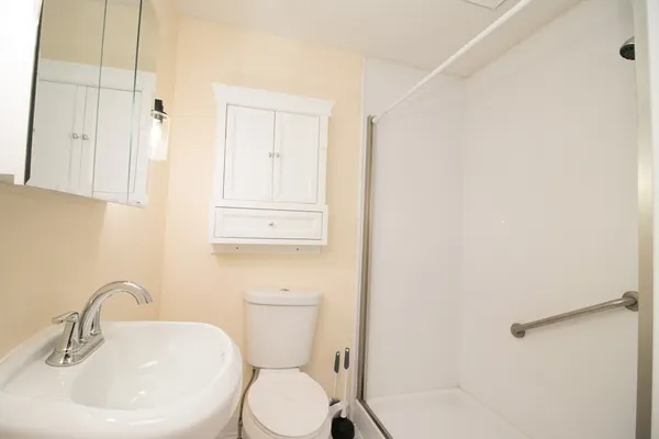 a bathroom with a sink a toilet and shower