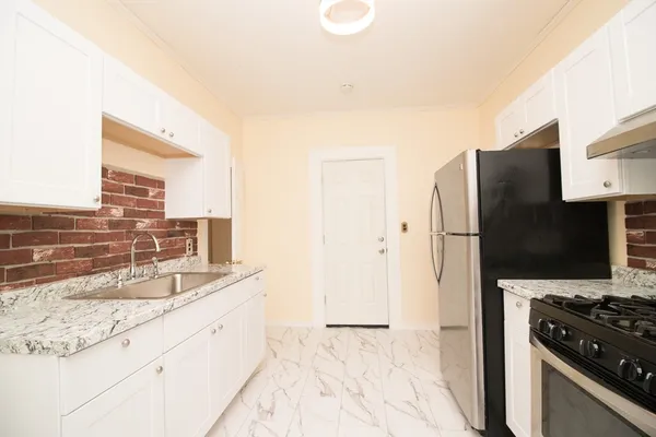 a kitchen with granite countertop a refrigerator and a sink