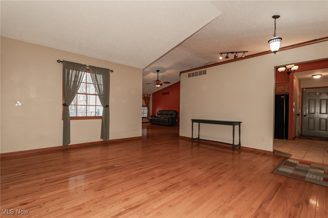4815 South Ridge Road Perry, OH 44081 - Photo 24 of 48 Unfurnished living room with vaulted ceiling, light wood-type flooring, and track lighting