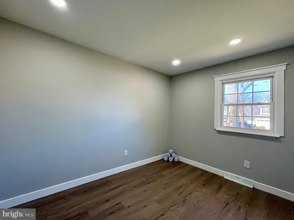 a view of empty room with wooden floor and furniture