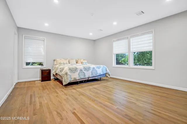 a view of a bedroom with a bed and wooden floor