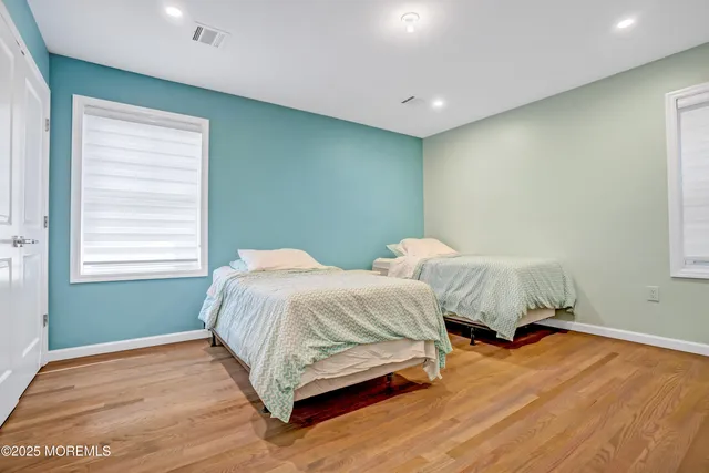a spacious bedroom with two beds and a window