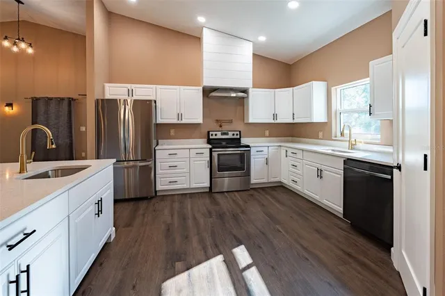a kitchen with stainless steel appliances a stove a sink and a refrigerator