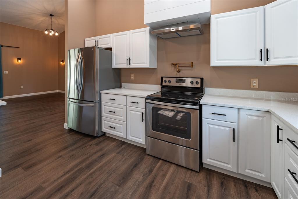 6425 Cartwrite Road Spring Hill, FL 34609 - Photo 16 of 74 a kitchen with stainless steel appliances a stove a sink and a refrigerator