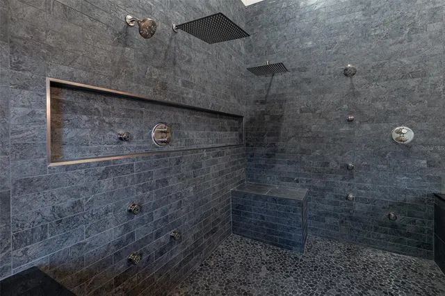 an empty room with wooden floor chandelier fan and windows