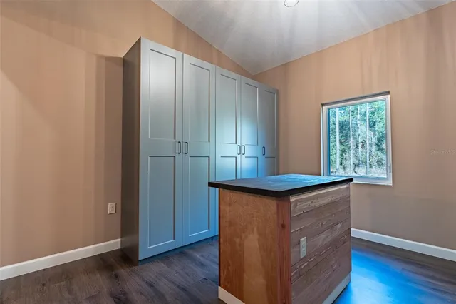 an empty room with wooden floor cabinet and a ceiling fan